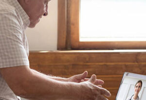 Man having doctor visit through computer