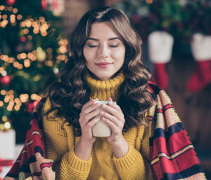 Woman smelling hot cup of coffee
