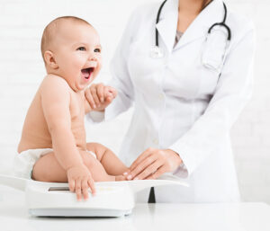 Baby getting weighed by pediatrician
